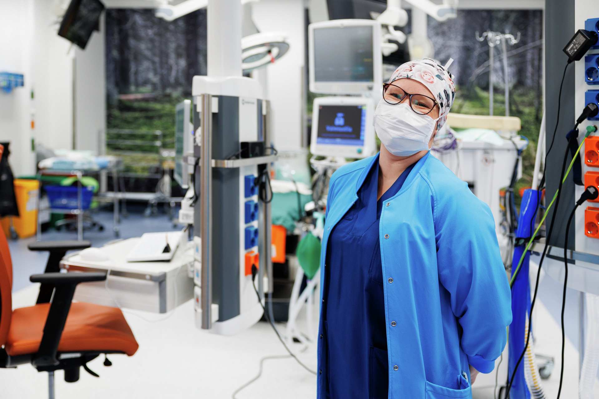 Leikkaussalin sairaanhoitaja seisoo leikkaussalin oven suussa.