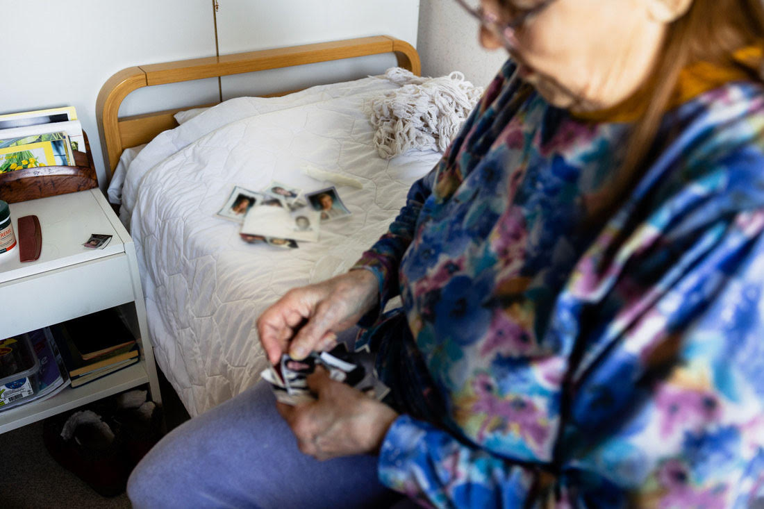 Polvijärven yhteisöasumisen yksikkö. Asukas katselee valokuvia.