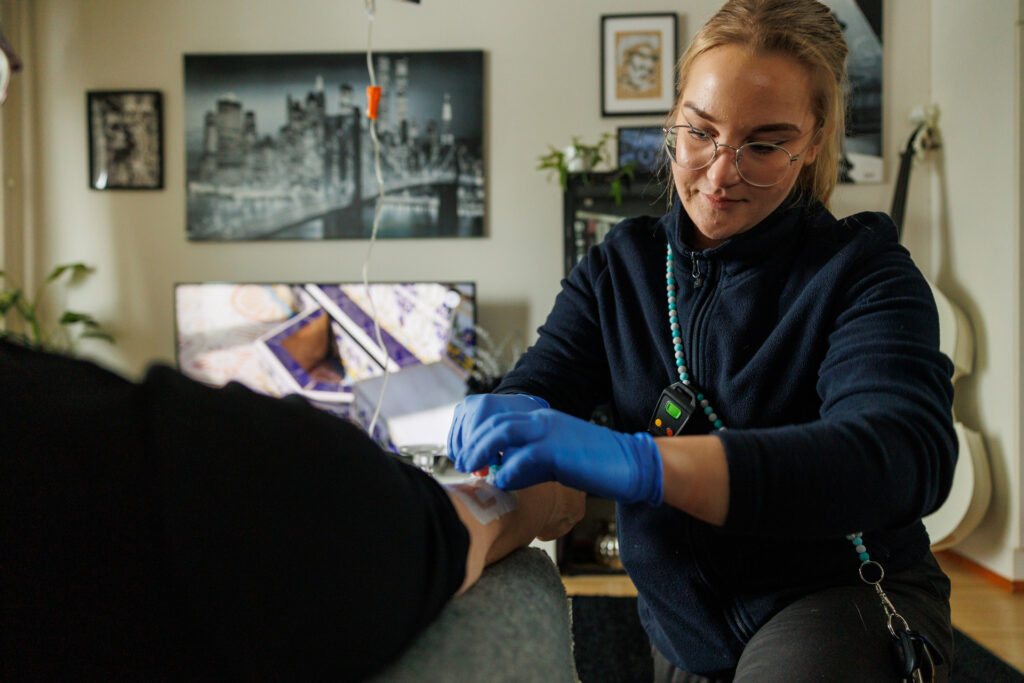 Sairaanhoitaja laittaa tiputusta asiakkaalle.