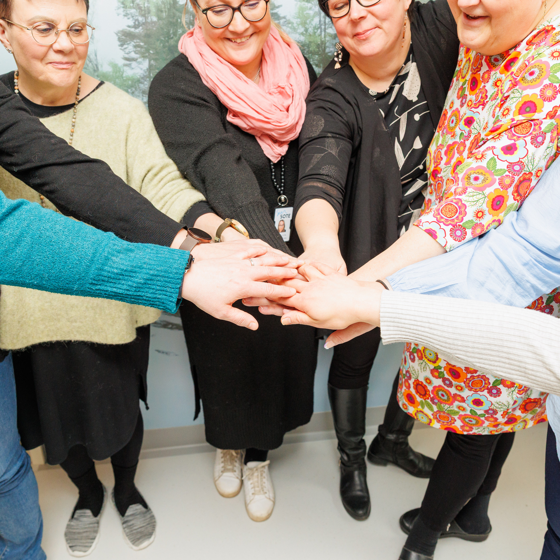 Monta ihmistä kädet yhdessä