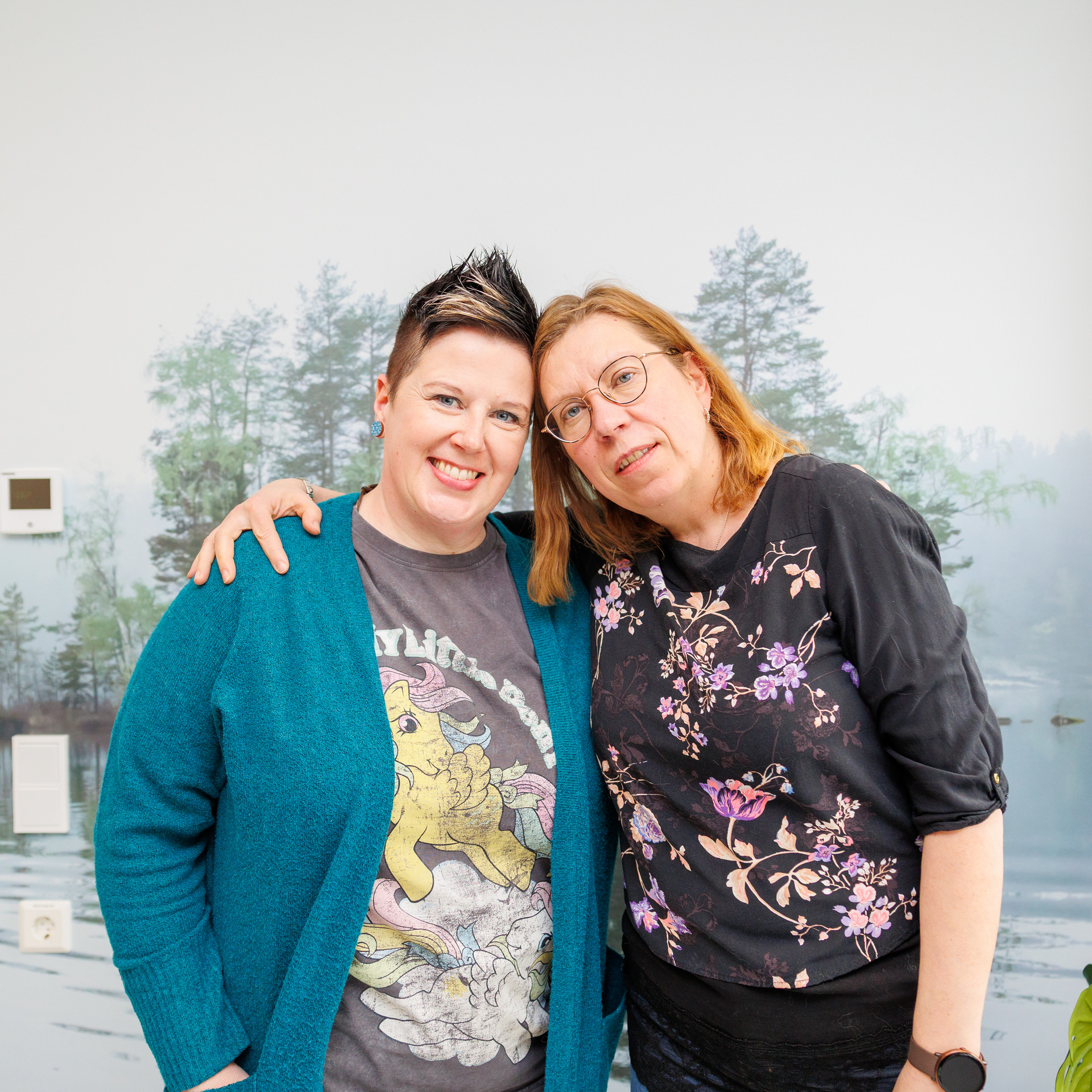 Kaksi ihmistä hymyilee ja halaa